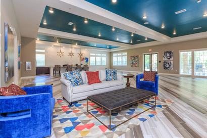 Parkdale clubhouse interior with white sofa, blue chair and blue accent paint on ceiling.