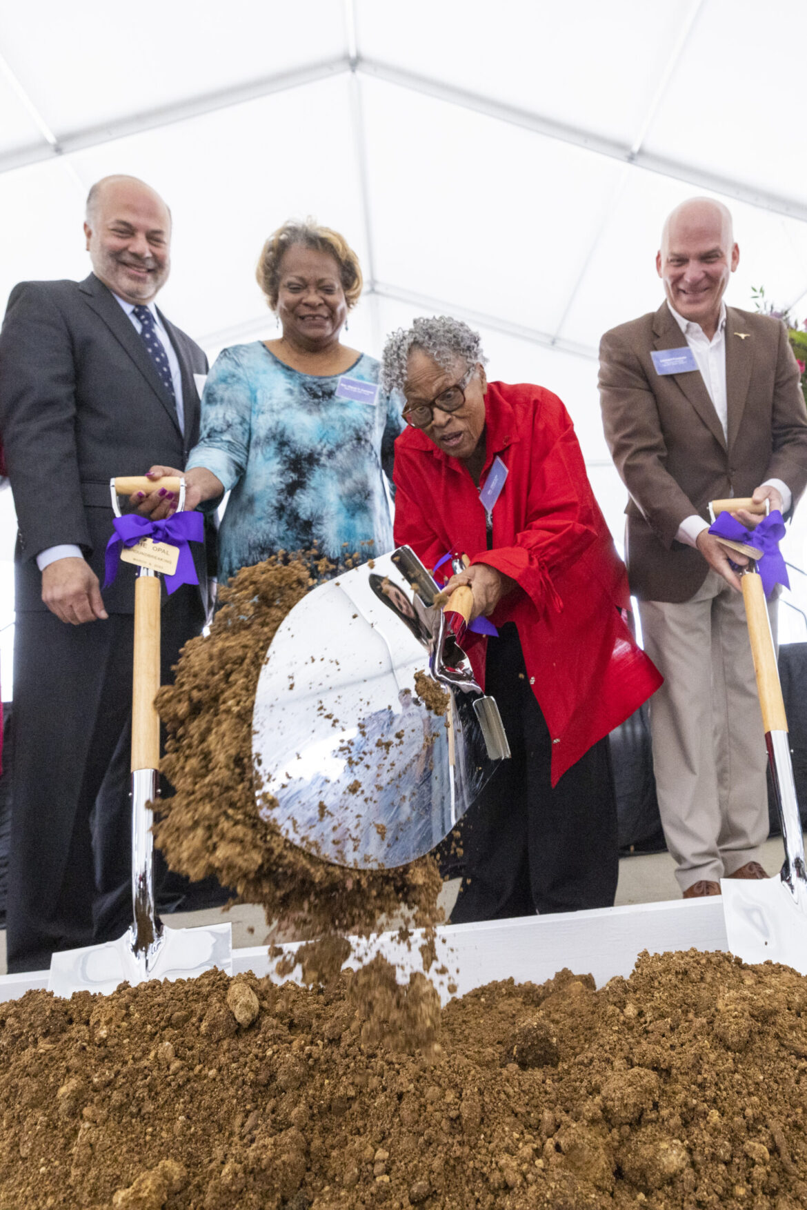 Opal Lee turning dirt with a shovel at The Lee groundbreaking ceremony.