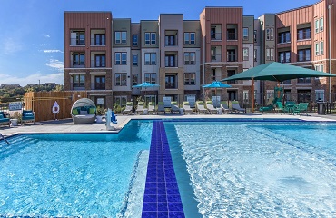 View of Spring Villas Apartments with pool in foreground.